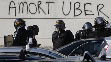 Des policiers lors des affrontements entre conducteurs de VTC et taxis en gr&egrave;ve, &agrave; Paris, le 25 juin 2015. ( CHARLES PLATIAU / REUTERS)