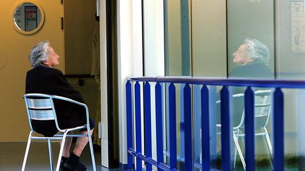 Une femme &acirc;g&eacute;e assise dans le couloir d'un h&ocirc;pital, &agrave; Beauvais (Oise).&nbsp; (PHILIPPE HUGUEN / AFP)