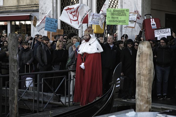 Devant la mairie, un homme habillé en "Doge", le dirigeant historique de la République de Venise, est monté à bord d'une gondole pour symboliser l'exode des habitants, samedi 12 novembre 2016. (MARCO BERTORELLO / AFP)