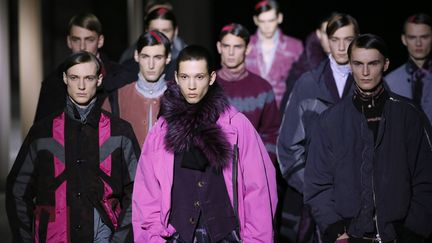 Le créateur belge ose faire porter du rose aux hommes, même du flashy, pour un pantalon, un imperméable, une veste croisée.... Après avoir exploité différentes nuances de cette couleur (jusqu'au mauve pour de la fourrure), il passe au bleu, au jaune puis au vert. Ils sont associés à des tons sombres, en version brute ou tie and dye. Dries Van Noten propose des pièces casuals (bombers, bermuda large, pantalon avec des empiècements) et d'autres aux coupes plus classiques (manteaux, chemise à jabot, vestes croisées). Le styliste mixe des vêtements que l'on n'imaginerait pas forcément ensemble, comme un pantalon large noir avec une veste en velours chic et près du corps.
 (PATRICK KOVARIK / AFP)