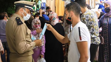 Distribution de masques sanitaires par la police le 17 août 2020 dans les rues de Marrakech, la capitale touristique du Maroc. (STR / AFP)