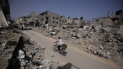 Des Palestiniens se déplacent entre des bâtiments détruits dans le camp de réfugiés de Bureij, le 21 mai 2024, (APAIMAGES/ SIPA)