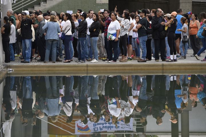 Des Vénézuéliens attendent leur tour pour voter au référendum organisé par l'opposition, dimanche 16 juillet 2017 à Caracas. (JUAN BARRETO / AFP)