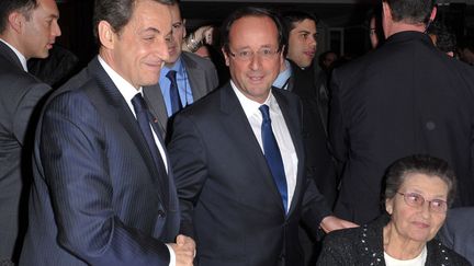 Le pr&eacute;sident fran&ccedil;ais Nicolas Sarkozy (G) sert la main de Fran&ccedil;ois Hollande, candidat socialiste &agrave; l'&eacute;lection pr&eacute;sidentielle (C) lors du d&icirc;ner annuel du CRIF &agrave; Paris, le 8 f&eacute;vrier 2012. (CHRISTOPHE GUIBBAUD / REUTERS)