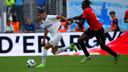 Le Marseillais Amine Harit et le Rennais Lesley&nbsp;Ugochukwu&nbsp;sur la pelouse du Vélodrome, le 18 septembre 2022. (NICOLAS TUCAT / AFP)