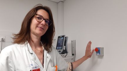 Le Dr Hélène Goulet, chef du service des urgences de l’hôpital Tenon, devant l’un des boutons d’alarme que peuvent actionner les soignants lorsqu’ils se sentent vulnérables face à un patient agressif. (SOLENNE LE HEN / RADIO FRANCE)