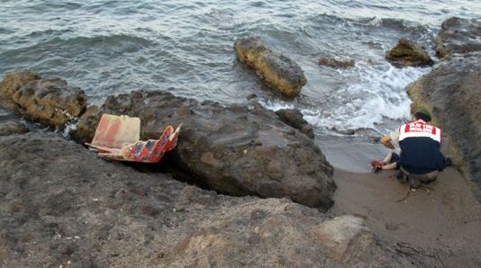 Un gendarme turc se penche sur le corps d'un enfant mort sur une plage de Bodrum (Turquie), le 2 septembre 2015.