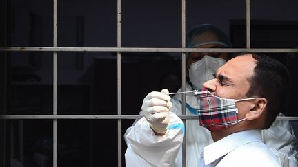 Un homme est testé pour le Covid-19 dans un centre de dépistage à New Delhi (Inde), le 19 octobre 2020. (SAJJAD HUSSAIN / AFP)