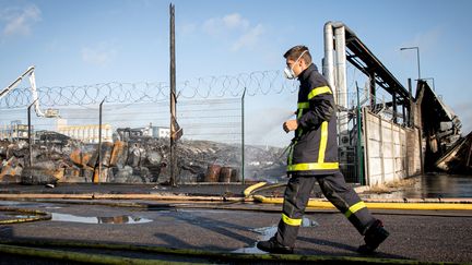 Un pompier marche&nbsp;dans l'usine Lubrizol de Rouen, le 27 septembre 2019, au lendemain de l'incendie. (LOU BENOIST / AFP)