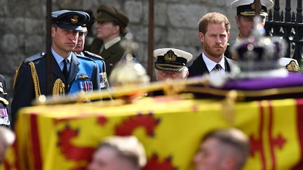 Le prince William (à gauche) et le prince Harry (à droite) suivent le cercueil de la reine Elizabeth II,&nbsp;orné de la couronne impériale pendant les funérailles à Westminster Abbey à Londres (Royaume-Uni), le 19 septembre 2022.&nbsp; (OLI SCARFF / AFP)