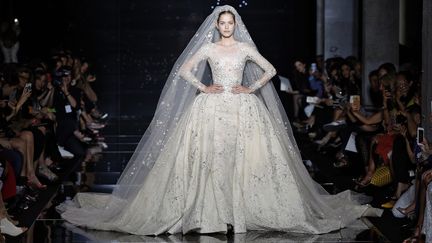 Pour le couturier Zuhair Murad, une pléiade de robes longues ou minis, fourreaux fuselés ou envolées cosmiques, allures de divas ou sensuelles déesses avec décolletés, transparences, fentes, drapés, tailles soulignées… mais aussi bodies et jumpsuits, manteaux, capes et étoles constellés de broderies, paillettes et cristal. La palette à la faveur du pourpre, noir, grenat, bleu, argent, gris… 
 (Zuhair Murad)