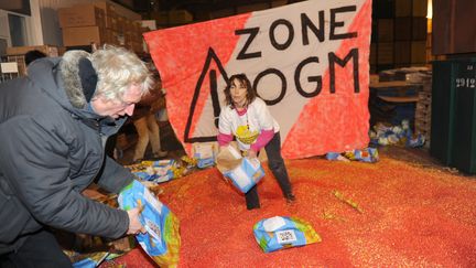 Des militants anti-OGM vident des sacs de ma&iuml;s transg&eacute;nique, le 23 janvier 2012, sur un site de Monsanto &agrave; Tr&egrave;bes (Aude). (ERIC CABANIS / AFP)