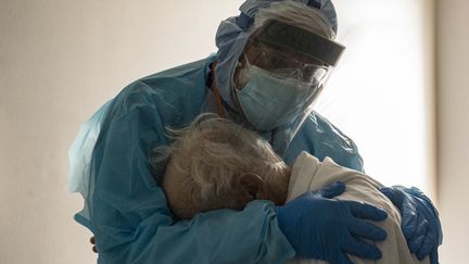 Le Dr Joseph Varon réconforte dans ses bras un patient atteint du Covid-19 dans une unité de soins intensifs de&nbsp;l'hôpital United Memorial de Houston, au Texas (Etats-Unis), le 26 novembre 2020. (GO NAKAMURA / GETTY IMAGES NORTH AMERICA / AFP)