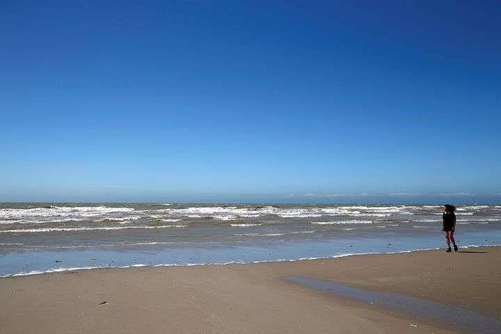 Béatrice Huret marche sur la plage de Dannes (Pas-de-Calais), le 15 juin 2017, un an après le départ de&nbsp;trois migrants iraniens depuis cette même plage. (PASCAL ROSSIGNOL / REUTERS)