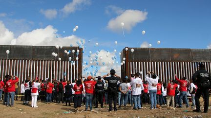 A près de 2 000 kilomètres de leur point de départ, des familles de migrants situés de part et d'autre de la frontière américano-mexicaine au niveau de Cuidad Juarez ont organisé un lâcher de ballons, le 13 octobre 2018, dans le cadre d'un évènement baptisé&nbsp;"Abrazos No Muros" ("des câlins, pas des murs). (HERIKA MARTINEZ / AFP)