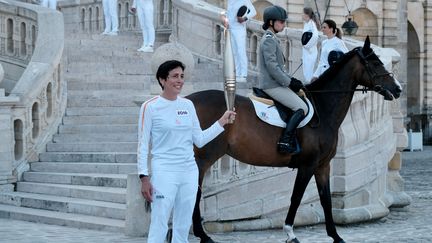 Blandine Lacheze, triathlète, arrive avec la flamme olympique dans la cour des Adieux du château de Fontainebleau (Seine-et-Marne), le 20 juillet 2024. (BABETH ALOY / HANS LUCAS / AFP)