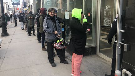 Des clients font la queue devant&nbsp;la boutique de la Société québécoise du cannabis (SQDC) de la rue Sainte-Catherine, principale artère commerciale de Montréal (Canada), le 18 mars 2020. (JACQUES LEMIEUX / AFP)