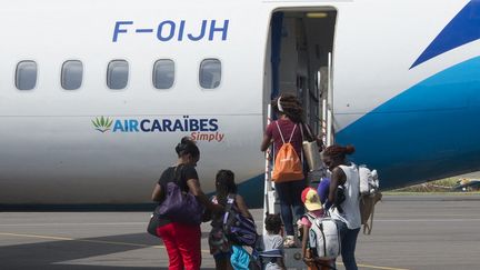 Des voyageurs embarquent à bord d'un avion en direction de la Guadeloupe, le 21 septembre 2017, à l'aéroport de Grand Case, à Saint-Martin. (HELENE VALENZUELA / AFP)