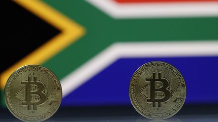 Pièces de bitcoin sur fond de drapeau sud-africain. Photo d'illustration, le 18 mai 2021. (MUSTAFA CIFTCI / ANADOLU AGENCY)