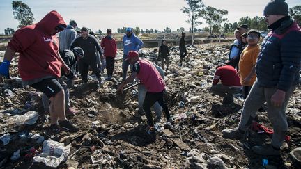 Des personnes fouillent dans la décharge de&nbsp;Las Parejas (Argentine) dans l'espoir d'y trouver des billets. (STR / AFP)