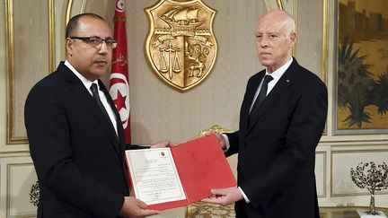 Le ministre de l'Intérieur Hichem Mechichi (à gauche)&nbsp;a été nommé le 25 juillet Premier ministre par le&nbsp;president tunisien Kaïs Saïed. Les deux hommes posent au palais de Carthage, à Tunis.&nbsp; (STRINGER / TUNISIAN PRESIDENCY)