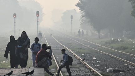 Un écolier traverse une voie ferrée dans des conditions de "smog", à Lahore, au Pakistan, le 4 novembre 2024, (ARIF ALI / AFP)