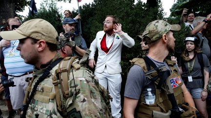 Un suprémaciste blanc se tient devant des&nbsp;manifestants antiracistes, samedi 12 août. (JOSHUA ROBERTS / REUTERS)