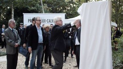 Au centre,Christophe Deloire, secrétaire général de Reporters Sans Frontières, lors de l'inauguration d'une stèle en hommage aux journalistes disparus, lors du Prix Bayeux 2014. La plaque est dévoilée par John Foley, père du journaliste assassiné en Irak. (CHARLY TRIBALLEAU / AFP)