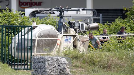 Des enquêteurs inspectent l'hélicoptère utilisé par Redoine Faïd et ses complices pour s'évader de la prison de Réau (Seine-et-Marne), le 1er juillet 2018. (IAN LANGSDON / MAXPPP)