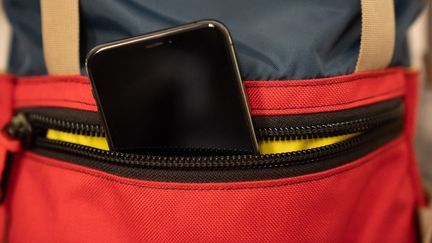 Un smartphone dans la poche d'un sac à dos. (CONSTANT FORME-BECHERAT / HANS LUCAS / AFP)