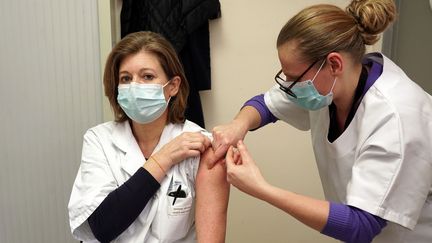 Une&nbsp;médecin administre une dose du vaccin Pfizer-BioNtech&nbsp;contre le Covid-19 à une&nbsp;consœur, le 5 janvier 2021 au CHU de Lille (Nord). (SYLVAIN LEFEVRE / HANS LUCAS / AFP)