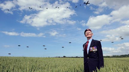 Frederick Glover, ancien combattant britannique de la Seconde Guerre mondiale, pose devant des parachutistes lors d'une commémoration du 70e anniversaire du débarquement allié en Normandie, le 5 juin 2014 à Ranville (Calvados). (THOMAS BREGARDIS / AFP)