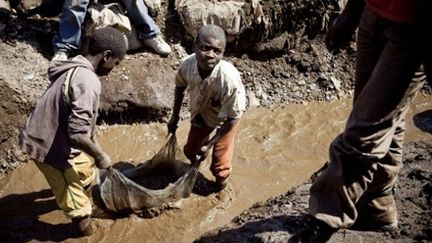 Des enfants lavent le cuivre dans la mine à ciel ouvert de Kamatanda (province du Katanga, sud de la RDC), 9-7-2010. (AFP - GWENN DUBOURTHOUMIEU)