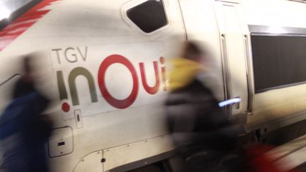 Des passagers marchent devant un TGV InOui de la SNCF en gare de Lille Flandres un soir de février 2020. (AURÉLIEN ACCART / RADIO FRANCE)