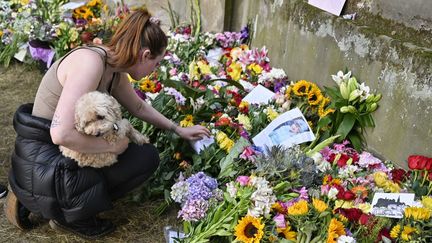 Avant l'arrivée du cercueil d'Elizabeth II, dimanche 11 septembre, des centaines de bouquets de fleurs et de cartes ont été déposés devant le palais de Holyrood, à Edimbourg. (LOUISA GOULIAMAKI / AFP)