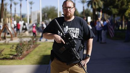 Un homme pose avec son fusil AR-15 lors d'une manifestation pour d&eacute;fendre le deuxi&egrave;me amendement de la Constitution am&eacute;ricaine, qui garantit le droit de porter des armes pour tout citoyen am&eacute;ricain, &agrave; Phoenix (Arizona, Etats-Unis), le 19 janvier 2013. (JOSHUA LOTT / REUTERS)