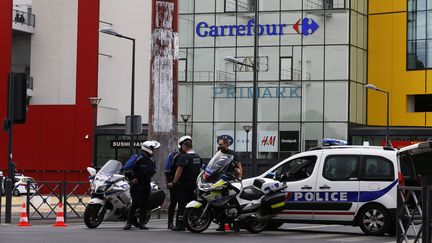 Ders policiers devant le centre commercial Qwartz de Villeneuve-La-Garenne (Hauts-de-Seine), le 13 juillet 2015. (THOMAS SAMSON / AFP)