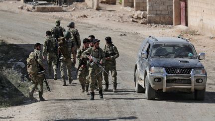 Des combattants syriens participant à l'offensive de la Turquie près de la ville frontalière de Tal Abyad (Syrie), le 12 octobre 2019. (KHALIL ASHAWI / REUTERS)