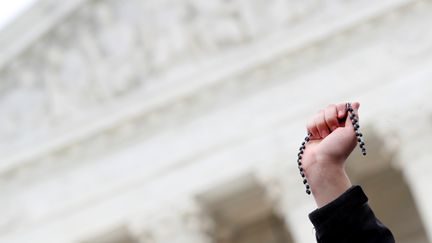 Un manifestant "pro-vie" lève un chapelet devant la Cour Suprême. (AARON BERNSTEIN / REUTERS)