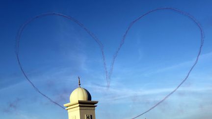 D&eacute;monstration de la Patrouille de France au dessus d'une mosqu&eacute;e &agrave; Duba&iuml;, le 14 novembre 2011. (KARIM SAHIB / AFP)