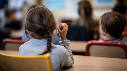 Une élève écoute un professseur dans une classe le jour d ela rentrée dans un école élémentaire à Paris, le 2 septembre 2019. Photo d'illustration. (MARTIN BUREAU / AFP)