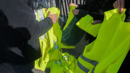 Des manifestants tiennent leur gilet jaune à la main, le 15 novembre 2018, à Clermont-Ferrand (Puy-de-Dôme).&nbsp; (MAXPPP)