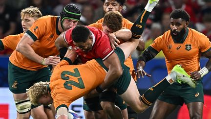 Le demi de mêlée australien Carter Gordon sèchement plaqué par le Gallois Taulupe Faletau, dimanche 24 septembre 2023 lors de Galles-Australie (40-6). (OLIVIER CHASSIGNOLE / AFP)