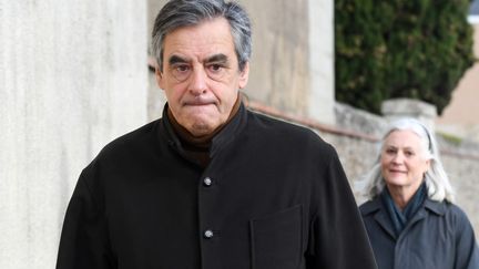 L'ancien Premier ministre François Fillon et son épouse Penelope, en arrière-plan, le 15 décembre 2019, à Sablé-sur-Sarthe. (JEAN-FRANCOIS MONIER / AFP)