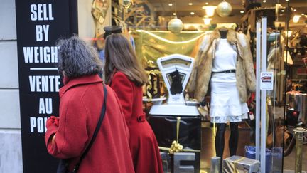 Deux passantes devant une vitrine de boutique décorée pour les fêtes de fin d'année.&nbsp; (AURELIEN MORISSARD / MAXPPP)