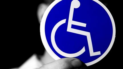 Un homme handicapé montre le logo "handicap". (PHILIPPE TURPIN / MAXPPP)