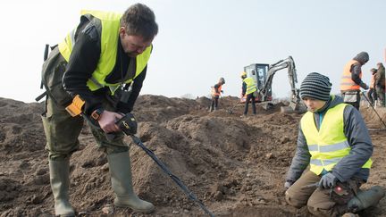 Un archéologiste amateur René Schön et un écolier de 13 ans Luca Malaschnitschenko&nbsp;procèdent à des recherches à l'aide d'un détecteur de métaux à Schaprode (Allemagne), le 13 avril 2018. (STEFAN SAUER / DPA / AFP)