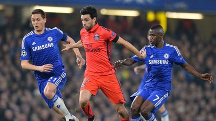 Le milieu de terrain du PSG, Javier Pastore, au duel avec deux joueurs de Chelsea, &agrave; Londres (Angleterre), le 11 mars 2015. (GLYN KIRK / AFP)