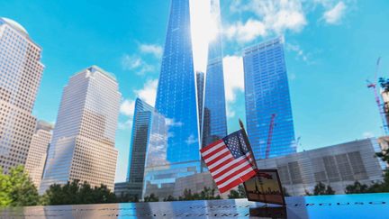 10 septembre 2021, New York. Le drapeau américain&nbsp;orne&nbsp;le tablier des bassins du&nbsp;Memorial du 11 septembre où sont inscrits les noms des personnes&nbsp;qui sont mortes lors de l'attaque terroriste du 11 septembre 2001.&nbsp; (ROBERTO SCHMIDT / AFP)