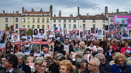 Demonstrators hold up portraits of hostages on October 7, 2024 in Lyon during a tribute to the victims of Hamas. (OLIVIER CHASSIGNOLE / AFP)